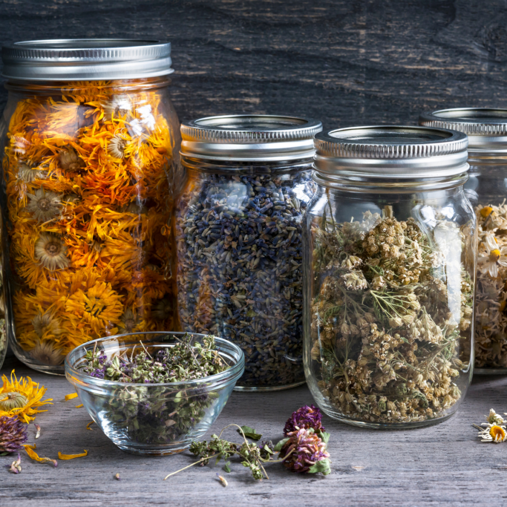 3 Apothecary jars with lids full of dried flowers - glass bowl with dried flowers in foreground