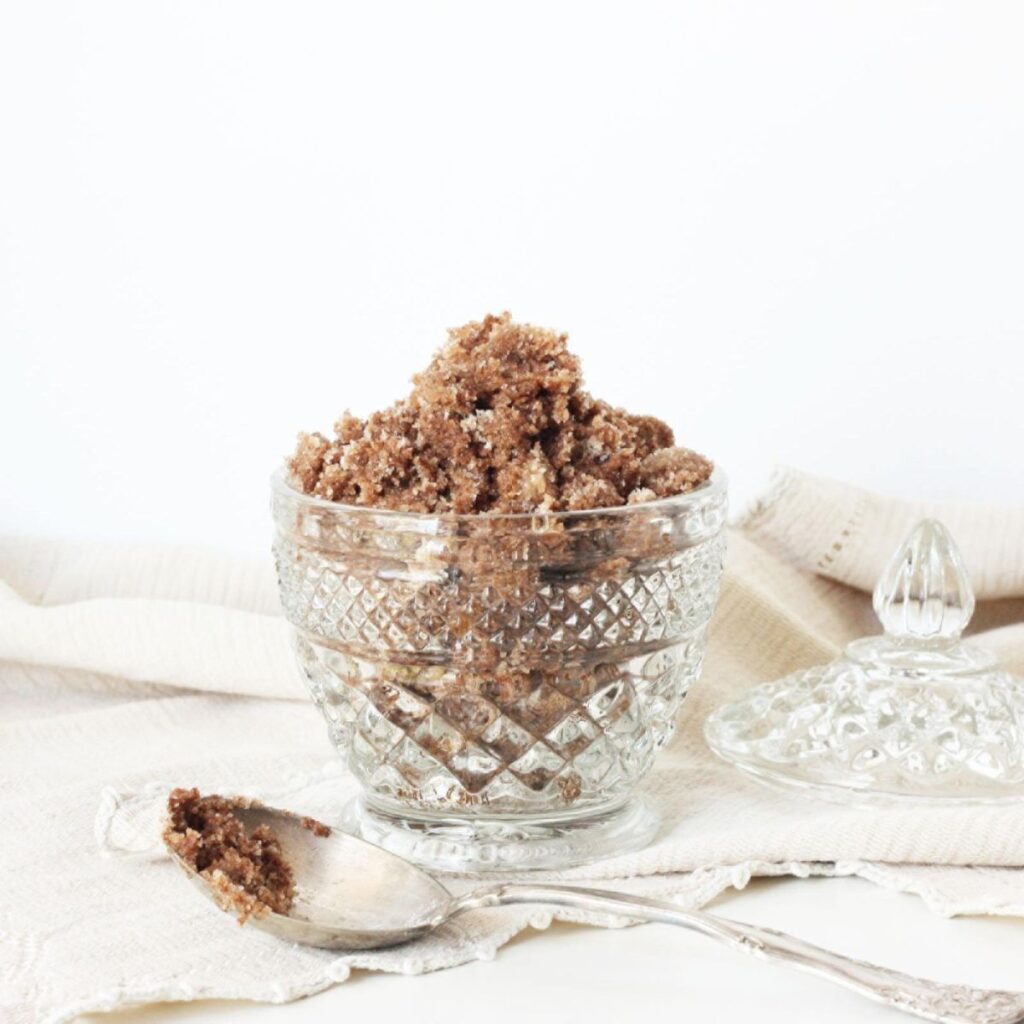brown sugar and cinnamon sticks in a crystal bowl on tabletop - ingredients for brown sugar and cinnamon sugar scrub