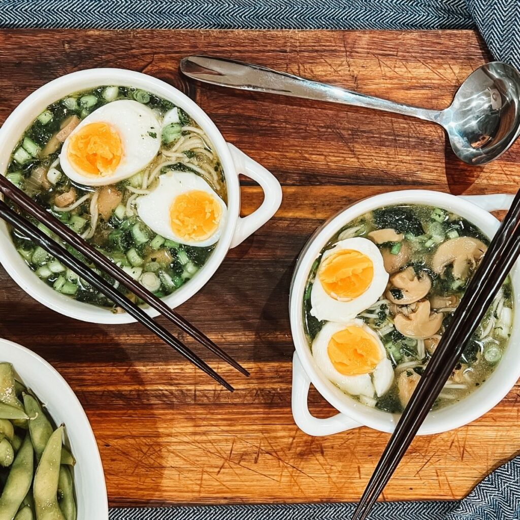 Bowls of ramen soup on top of a wooden table. 