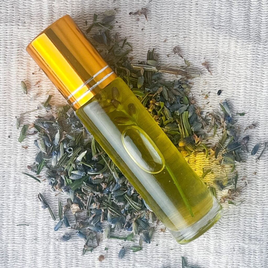 Lip oil laying flat on a mound of dried lavender buds.