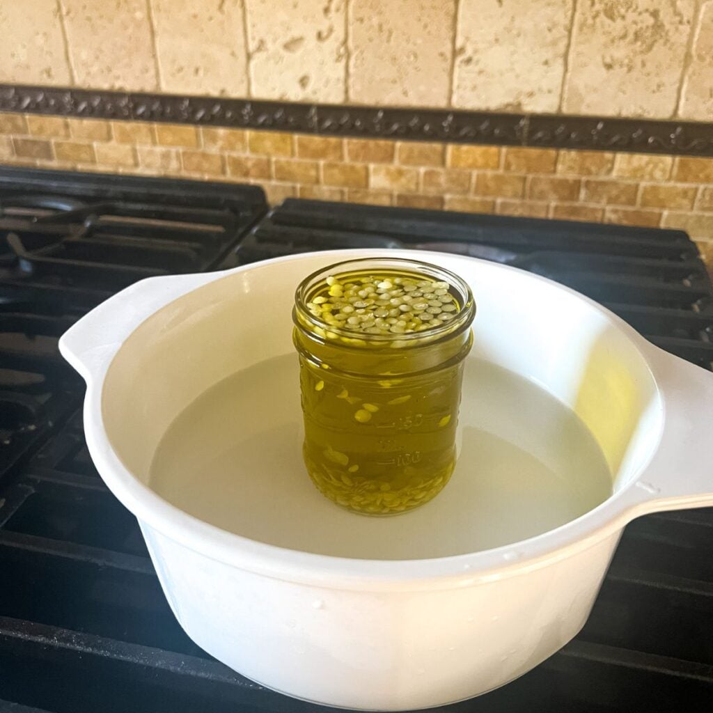 lavender-infused olive oil with the beeswax in a mason jar in a double boiler.